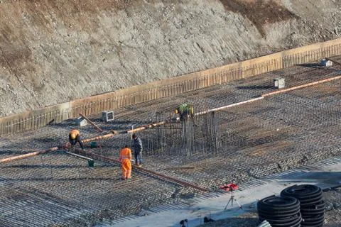 Construction of the building. Workers unrecognizable make metal reinforcement Stock Photos