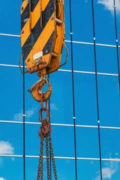 Construction of buildings: a crane hook, chains and cables on the background  Stock Photos
