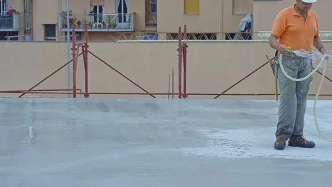Construction carpenter waters the surface of a reinforced concrete floor slab Vídeo Stock 291948388