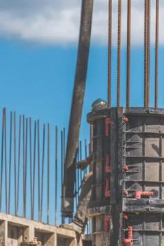 The construction, cement pouring with machine into the frame of the house, wo Фото