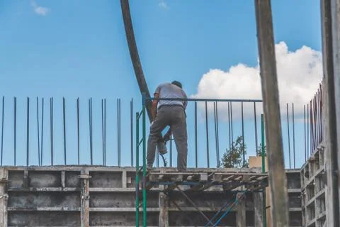 The construction, cement pouring with machine into the frame of the house, wo 库存照片