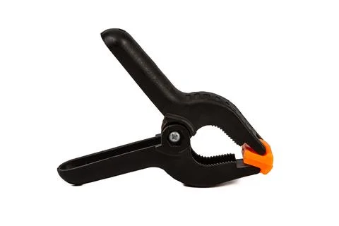 Construction clip, black plastic clip with orange tips isolated on white back Stock Photos