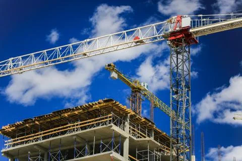 Construction concept. A new building under construction against the sky. Blue Stock Photos