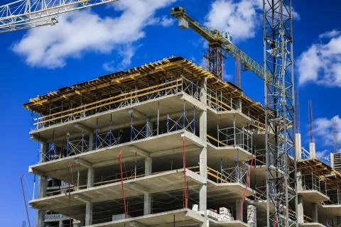 Construction concept. A new building under construction against the sky. Blue Stock Photos