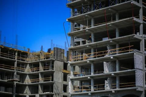Construction concept. A new building under construction against the sky. Blue Stock Photos