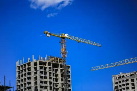 Construction concept. A new building under construction against the sky. Blue Stock Photos