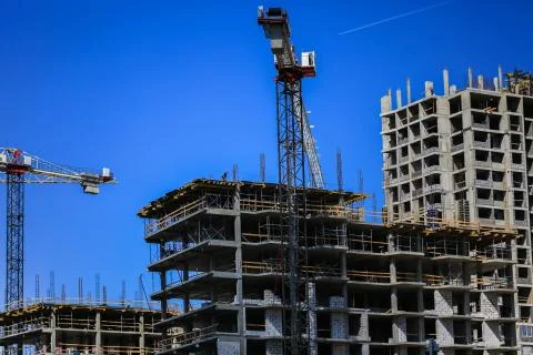 Construction concept. A new building under construction against the sky. Blue Stock Photos