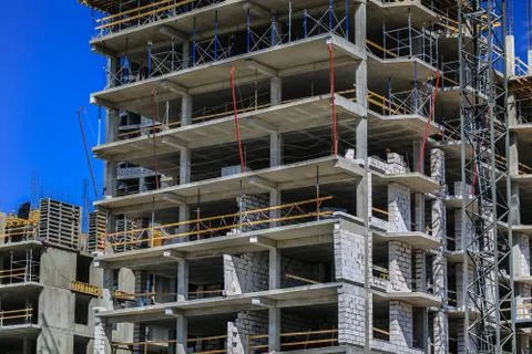 Construction concept. A new building under construction against the sky. Blue Stock Photos