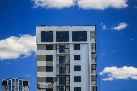 Construction concept. A new building under construction against the sky. Blue Stock Photos