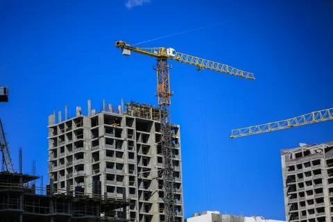 Construction concept. A new building under construction against the sky. Blue Stock Photos