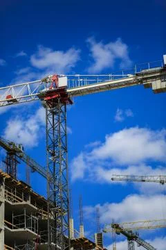 Construction concept. A new building under construction against the sky. Blue Stock Photos