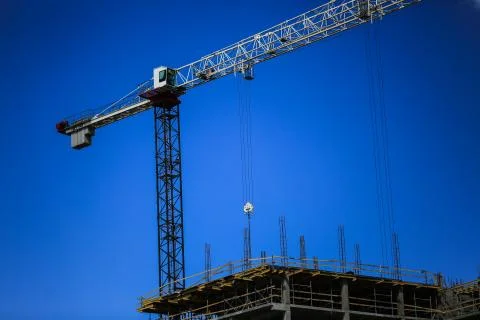 Construction concept. A new building under construction against the sky. Blue Stock Photos