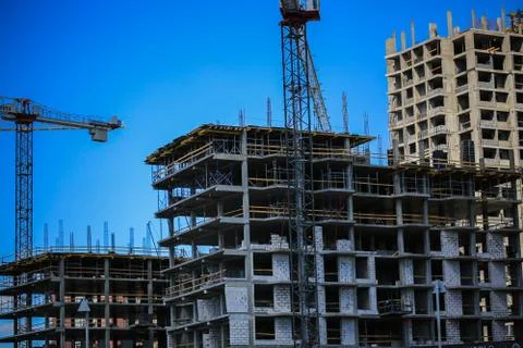 Construction concept. A new building under construction against the sky. Blue Stock Photos