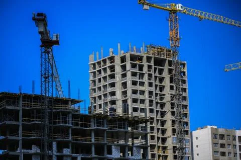 Construction concept. A new building under construction against the sky. Blue Stock Photos