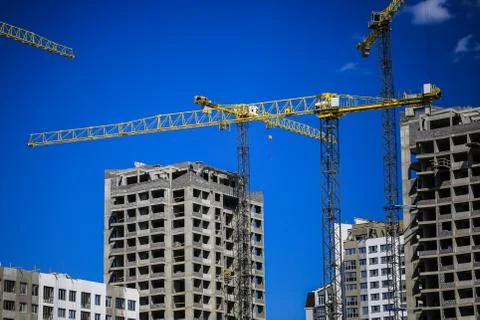 Construction concept. A new building under construction against the sky. Blue Stock Photos