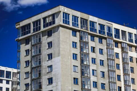 Construction concept. A new building under construction against the sky. Blue Stock Photos
