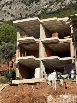 Construction of a concrete building structure with exposed brickwork in a r.. 库存照片