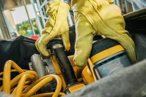 Construction Contractor Grabbing Power Tools From His Bag Фото