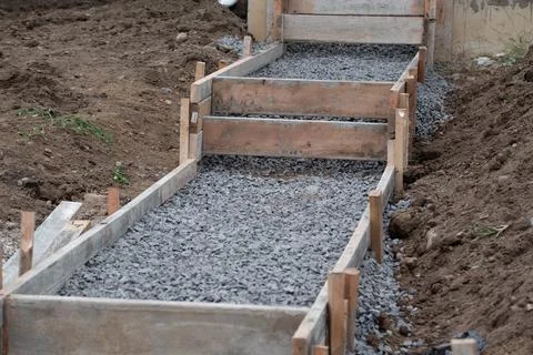Construction contractor installing a sidewalk, curb on a new urban road stree Stock Photos