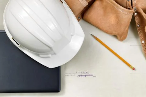 Construction contractor tools resting on top of blue print CAD drawings Stock Photos