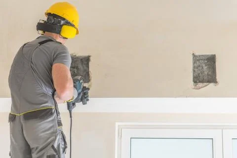 Construction Contractor Worker Drilling Inside Apartment Wall. 库存照片