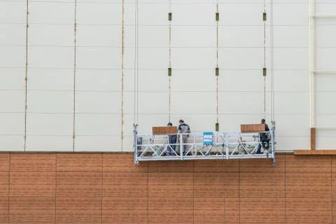 Construction cradle. Front elevator. Finishing a high-rise building. Stock Photos