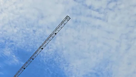 Construction crane against a cloudy blue sky. Minimalist illustration Stock Footage 297615308