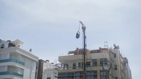 Construction crane and the building against the blue sky, hotel build Stock Footage 221879095