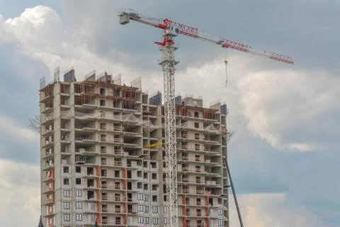 Construction crane and building under construction against blue sky. Fotos Stock