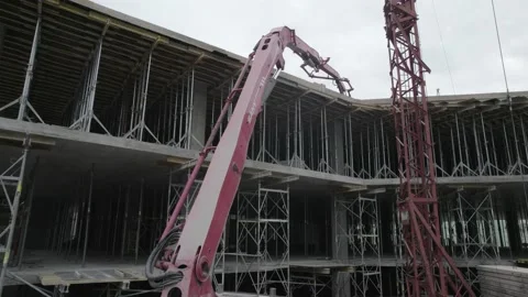 A construction crane and a concrete supply crane during the pouring of floors Stock Footage 219687210