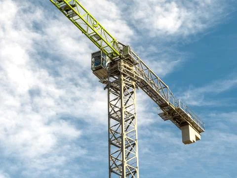 Construction crane arm close-up under bright blue cloudy sky Stock Photos