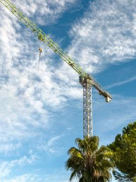 Construction crane arm close-up under bright blue cloudy sky Stock Photos