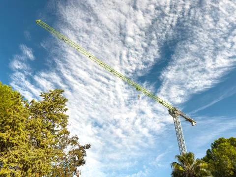 Construction crane arm close-up under bright blue cloudy sky Stock Photos