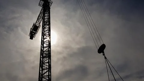 Construction crane on a background of blue sky. Close view of a constructio.. Stock Photos