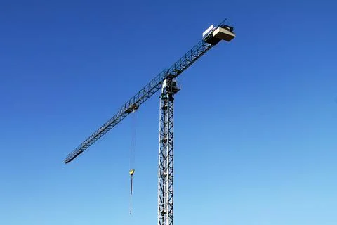 Construction crane on the background of a bright blue sky Foto stock
