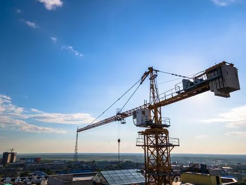 Construction crane on the background of a clear day sky aerial view. Flyby of Stock Photos