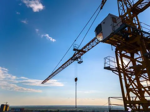 Construction crane on the background of a clear day sky aerial view. Flyby of Stock Photos