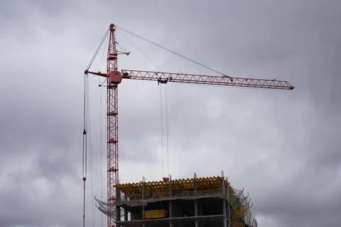 Construction crane on the background of the cloudy sky Stock Photos