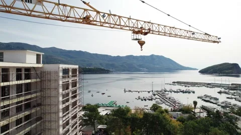 Construction crane on the background of the coast of Montenegro Stock Footage
