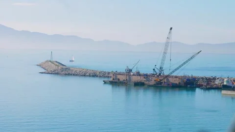 Construction crane barge working on harbor breakwater wall Stock-Footage 337569688