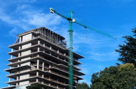 A construction crane on a blue sky background. Building construction. Stock Photos