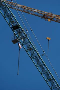 Construction crane on blue sky background, close-up. Industrial background Stock Photos