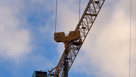 Construction crane boom moving with hook and chains against sky Video stock 346011689