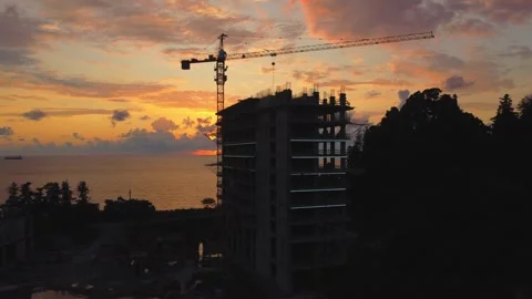 Construction crane building modern skyscraper at sunset Stock Footage 292807939