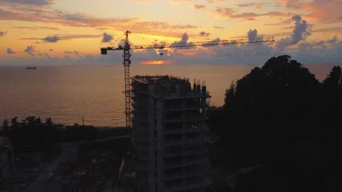 Construction crane building modern skyscraper at sunset Video stock 292808062