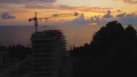 Construction crane building modern skyscraper at sunset Stock Footage 292808074