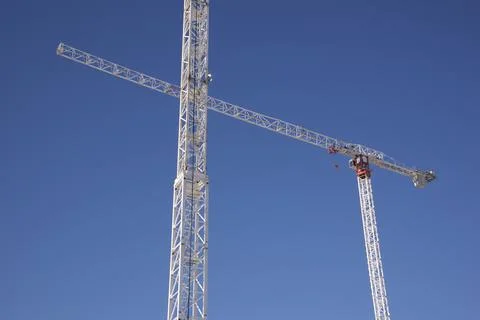 Construction crane in a construction site with clear blue sky Stock Photos
