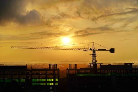 Construction crane at a construction site at dawn. Stock Photos