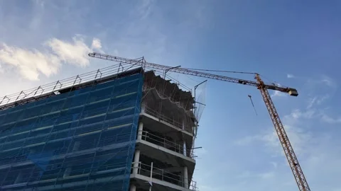 Construction crane demolishing a building under blue sky Stock Footage 304184243