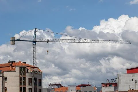Construction crane dominating skyline on cloudy day Stock Photos